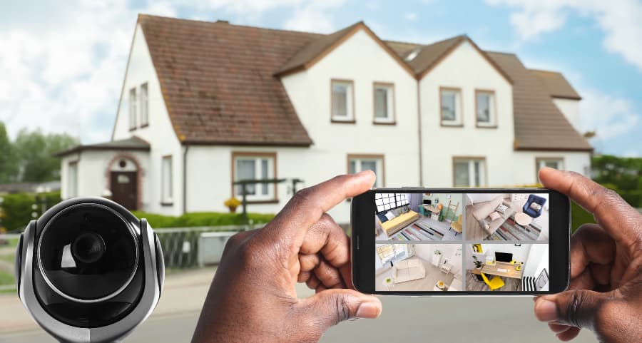 Man holding mobile device and looking at streams from security cameras